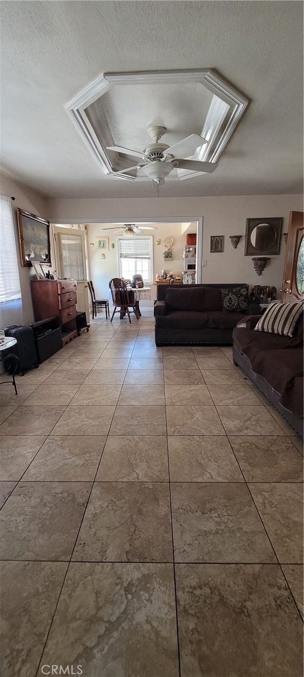 Living room facing towards kitchen. Tile flooring throughout.