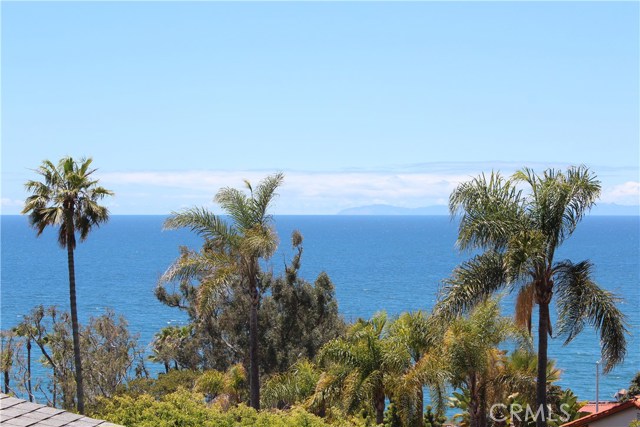 2555 Glenneyre Street Laguna Beach, California Enjoy panoramic ocean and Catalina views from this 2 bedroom and 2 bath home situated in Laguna Viillage! Middle unit with living space on one level. The kitchen has a breakfast bar, refrigerator, and opens to the dining area and living room with wood-burning fireplace and views! Shows light and bright with a spacious wrap-around deck with ocean breezes and ocean/sunset views. Includes a carport plus one parking space parked tandem. Separate storage area with coin laundry to share with 2 other units. Great location close to restaurants, shopping, and close to one of Laguna's most desirable beaches, Victoria Beach!