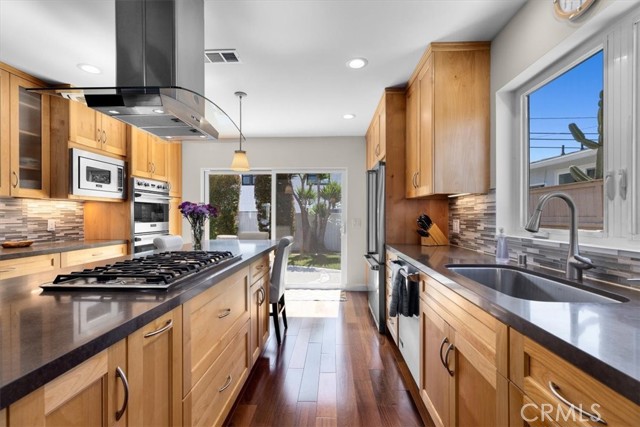 Kitchen has Viking appliances, breakfast bar, and direct access to the backyard via sliding door.