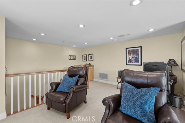 Wet bar at the top of the stairs behind the chairs in