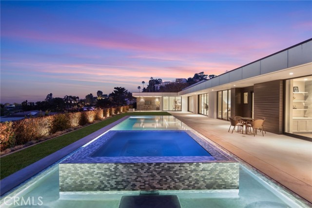 521 Chalette Drive Beverly Hills, California Set behind gates on one of Trousdale's most desirable streets, this fully reimagined architectural home showcases magnificent open space front courtyard along with spectacular city and ocean views from many rooms. Architecturally inspiring interiors pay tribute to midcentury design while exuding warmth and sophistication. A soaring great room with a Portoro marble fireplace and dining area is lined with Fleetwood walls of glass that bring gorgeous grounds and far-reaching views to the forefront. A staggering chef's kitchen with Calacatta gold counters, plush screening room, frameless glass garage doors and high-end Crestron smart home system fuse elegance and technology. Four ensuite bedrooms-including the magnificent master with sprawling, spa-like bath-are voluminous and bright, each lined with Fleetwood walls to a private patio or the pool terrace. Perfectly conceived for the California lifestyle, Fleetwood sliders join the interiors with grassy lawns, a zero-edge infinity pool and cabana overlooking breathtaking jetliner views.