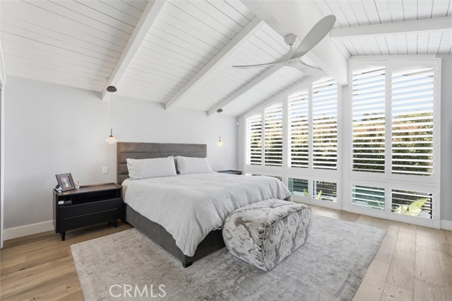 Primary bedroom with views over pool and newer custom shutters  shutters
