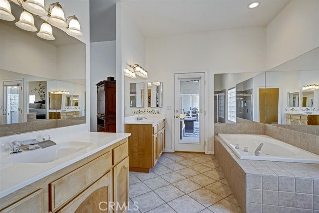 Primary Bath Featuring Double Vanity and Egress Door To Covered Patio.