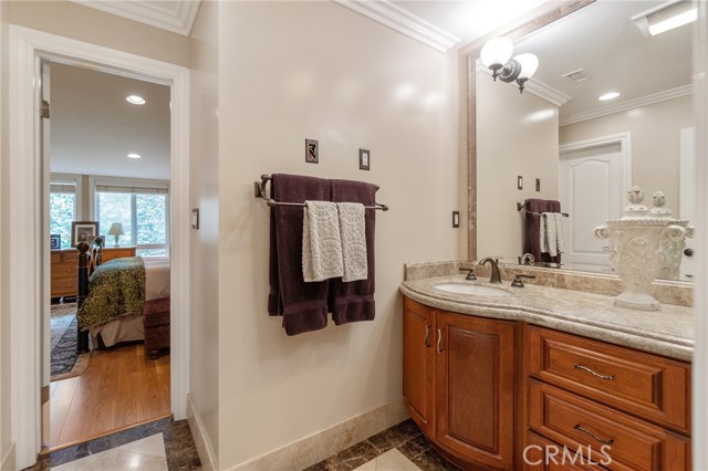 Master bath with granite counters and rich wood cabinets