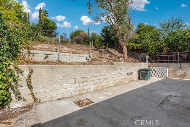 Block Wall to Terraced Area. Backyard extends up the hill. More space to plant and grow...