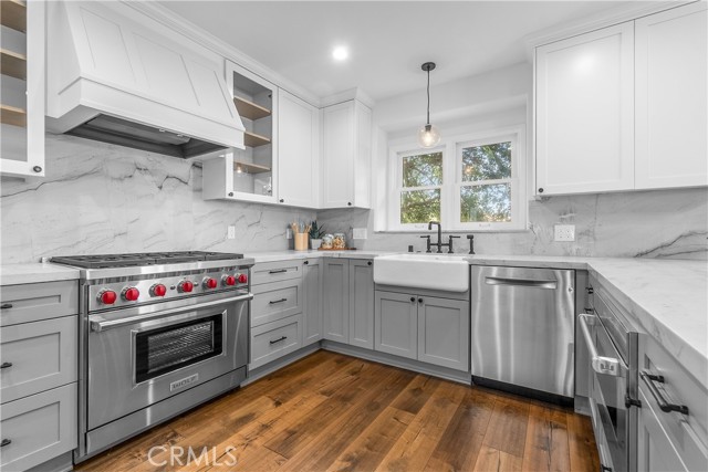 An enviable kitchen featuring top of the line Wolf appliances, Sub-Zero refrigerator, ample quartzite countertops, and gorgeous solid wood cabinetry.