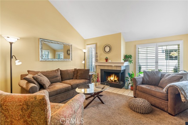 Bright Living Room with Vaulted Ceiling, Fireplace and Plantation Shutters