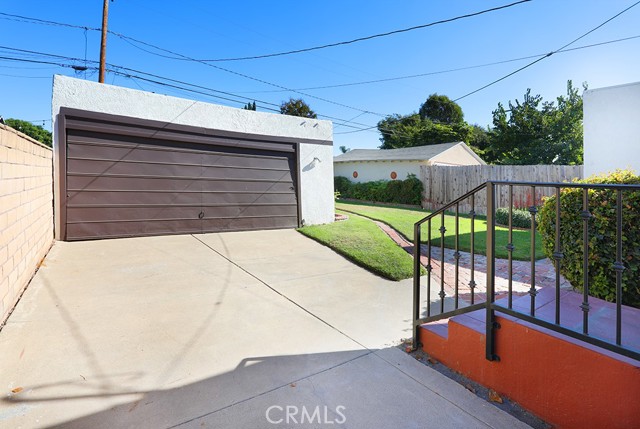 Heading outside, to the back. There’s a gated driveway and two car garage.