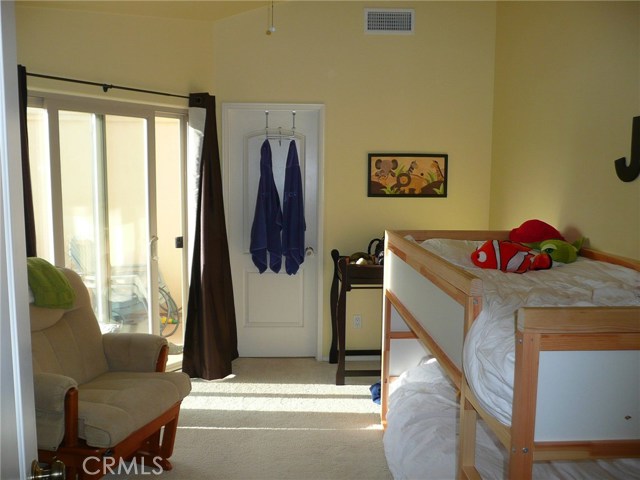 Bedroom #2 with a private balcony/deck (photo was taken with a prior occupant's furniture)