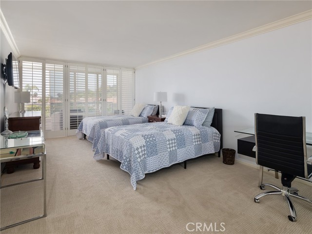 En suite spacious primary bedroom with room for a desk or seating area, bright natural light.