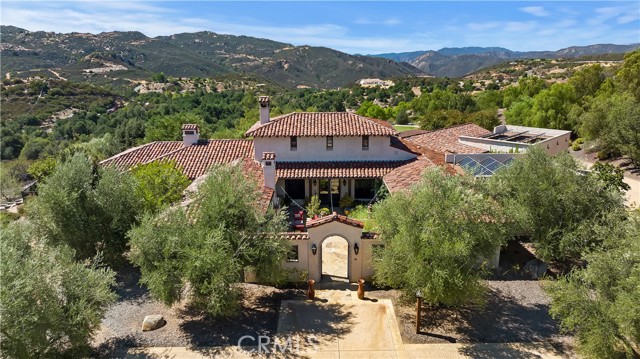 Luxury at its finest. This immaculate private estate is located in the very desirable Santa Rosa West with over 28+ acres of manicured and irrigated land with endless stunning unobstructed views. Enter through the iron gates and feel worlds away, yet just minutes from schools and shopping. Meandering up the beautiful drive you will find 2 pastures to turn the horses out and let the them graze and enjoy the land, a lighted arena and a raised center aisle BarnMaster Barn with 4 stalls, automatic waterers, stall mats, a secure feed room and separate tack room with half bath. Also located on right side of driveway is a graded pad with utilities ready to build a guest home. The fully landscaped drive continues all the way through the property to the back of the property where you will find a second entrance to the property so you have dual access. At the back of the property you will find a completely maintained mature orchard with numerous varieties of fruit trees for fresh fruit throughout the year. Before entering the home you can enjoy the beautiful evenings in your private courtyard and sit by the fireplace listening to the tranquil sound of your water fountain. This 5 bedroom, 4 bathroom single story Spanish style home is truly exquisite with details ranging from hand painted custom tile to the wood beamed ceilings. Enter thru the glass double doors to the large living open living room with custom stone fireplace and gaze out the sliding glass doors to your amazing backyard with endless views. Enjoy the large open kitchen with the Wolf 6 burner range and double oven and warming drawer, SubZero built in refrigerator, Bosch dishwasher and wine fridge. Have your own spa day in your Master Suite with a private hallway leading to the open and airy bedroom with fireplace and sliders out to the backyard, 2 closets and 2 restrooms. Light some candles and relax in the jetted tub while gazing out the huge windows at the stars and take a rejuvenating shower in the custom built Steam Shower. Entertain in the gorgeous backyard with the 70"x20" Salt water pool with diving board and 12'x 20' spa both Hydrozzo lining, BBQ area with it's own refrigerator, sink and warming drawer.  Delight guests at the separate bar that also includes a sink, refrigerator, ice maker and TV. Pool area also has it own outside shower and bathroom.  Don't worry about the dogs jumping on the guests as there is a covered dog run with 4 kennels. Home has paid off solar and whole house generator.