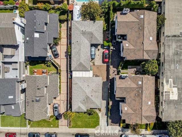 Drone view of lot showing 2 homes garage, driveway and front and back yards