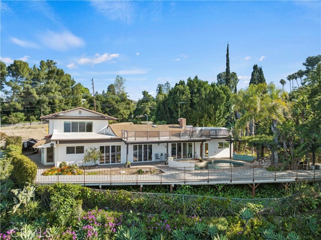 Discover the epitome of luxury living in Encino Hills, where breathtaking panoramic views of the San Fernando Valley meet unparalleled elegance. This stunning 5-bedroom, 4-bath estate is a masterpiece of sophistication and style. Step outside to your private oasis: an exquisite pebble-finished pool with a cascading waterfall and spa, all framed by the mesmerizing valley backdrop—ideal for relaxation and rejuvenation.Inside, the home welcomes you with a bright, open-concept layout and a recent modern renovation. Sunlight floods through expansive windows, enhancing every corner with warmth and inviting energy. The primary suite is a sanctuary, featuring breathtaking views, a spacious walk-in closet, and a spa-inspired bathroom complete with a sleek, oversized shower. For culinary enthusiasts, the gourmet kitchen is a dream come true. Outfitted with high-end appliances and quartz countertops, it provides the perfect space to indulge your creativity. Beyond the kitchen, the magic continues on the wrap-around rooftop deck. Here, lush gardens and mature trees create a tranquil ambiance, perfect for unwinding, entertaining, or simply soaking in the beauty of nature. This exceptional property combines modern design, awe-inspiring views, and luxurious amenities in one of Encino Hills' most coveted locations. Don’t miss the chance to make this remarkable home yours. Schedule a private showing today and experience luxury living at its finest.