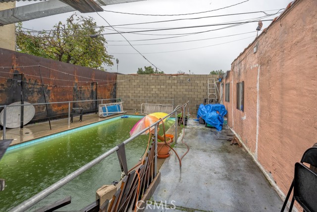 Pool,  back by the blue tarps is another entry door to garage storage area.