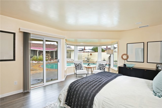 Primary bedroom with bay window and view of the pool