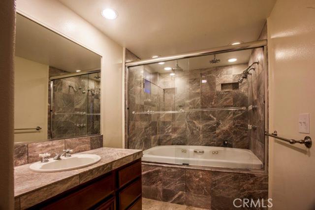 Master bathroom with oversize spa tub with multiple jets and shower nozzles. New hardware and lighting.