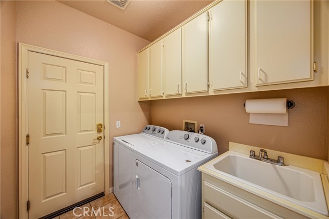 Laundry room with lots of cabinets and sink.