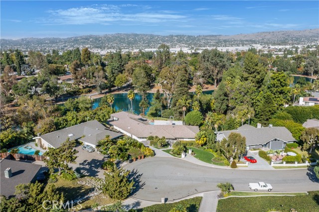 This Midcentury Modern gem in Sunny Hills Estates, overlooking Laguna Lake, sits on an expansive 28,000-square-foot lot. The secluded cul-de-sac location ensures privacy, complemented by a gated entrance and driveway. Boasting the widest lakefront setting in the neighborhood, the single-story home spans approximately 4,000 square feet. The interior showcases stunning lake views, onyx slate flooring, stainless steel appliances, and two stone fireplaces in both the living room and primary suite, creating an ambiance of timeless elegance. The spacious floor plan also includes a family room, a bonus room or office space, additional four bedrooms, five bathrooms, and various other amenities. The breathtaking backyard includes a pool, spa, covered patio, fire pit, and fruit trees. The sizable lot is truly one of the best in the neighborhood and not only provides an idyllic setting for relaxing and entertaining but also offers considerable potential for expansion. The beautiful neighborhood offers pristine landscaping throughout, walking/biking/horse trails, fishing at Laguna Lake and award-winning schools. This amazing home is ready for its new owners!