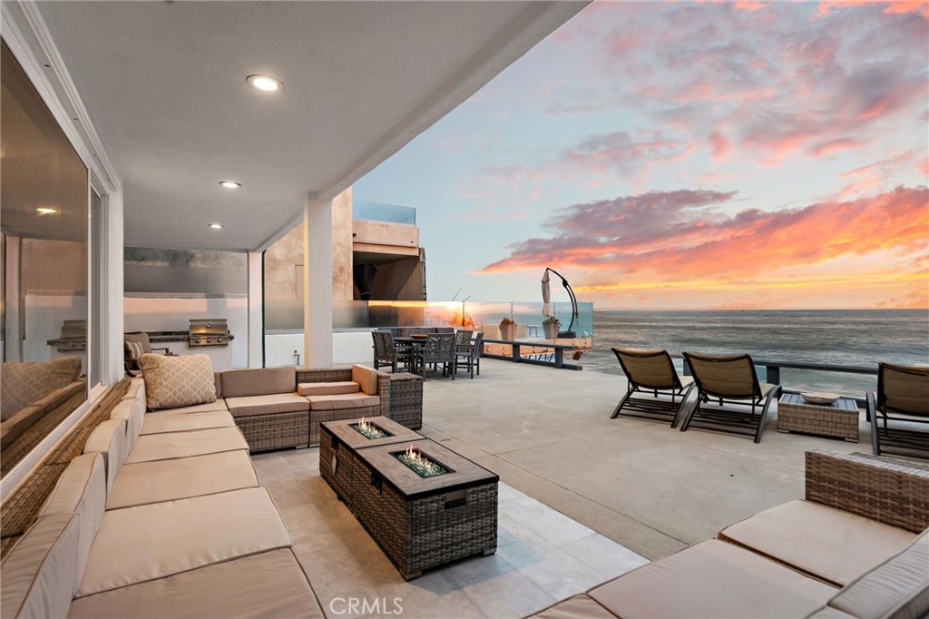 Discover the ultimate surfside lifestyle at this recently remodeled Spanish Contemporary home, enviably located right on the sand in the historically rich, guard-gated Capistrano Beach enclave of Beach Road. All-encompassing views dazzle with crashing waves, colorful sunsets, the deep-blue Pacific Ocean, and the bold silhouettes of Catalina Island and Dana Point’s towering Headlands. Views elevate living from interior spaces as well as a large beachfront terrace with a variety of entertaining areas and a covered patio with built-in BBQ island. Measuring nearly 1,965 square feet, the residence presents a boundless sense of openness, with a double-height ceiling showcased in a living room with linear fireplace, patio access and large clerestory windows. Dine in style between the living room and a beautifully appointed chef’s kitchen with a Viking range and dishwasher, white cabinetry, granite countertops with full matching backsplash, and a large built-in pantry. The first level is home to a secondary ocean-view bedroom, and a versatile bonus room/additional bedroom with outdoor access. A classic spiral staircase ascends to the bright and airy home’s second-floor hall, which overlooks the living room and leads to a laundry room and two more bedrooms, including one with a large ocean-view balcony. Private parking for four and a storage building are located right across the street from the residence, which occupies a homesite of approximately 3,485 square feet. Wood-look tile, designer carpet and luxury vinyl plank flooring complement a white color scheme throughout the turnkey home. Stretching across 1.5 miles of private beach and offering about 185 homes, 24-hour guard gated Beach Road has a stellar setting near Dana Point's harbor, the popular Lantern District, coastal trails, top schools, and the coastal towns of San Clemente and Laguna Beach.