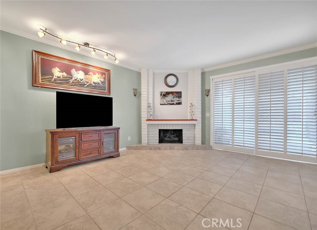 Large & Airy Living Room.  Corner Natural Gas Fireplace For Cozy Warmth.  Wood Plantation Shutters Lead To Backyard Covered Patio.  Easy Clean Tile Flooring