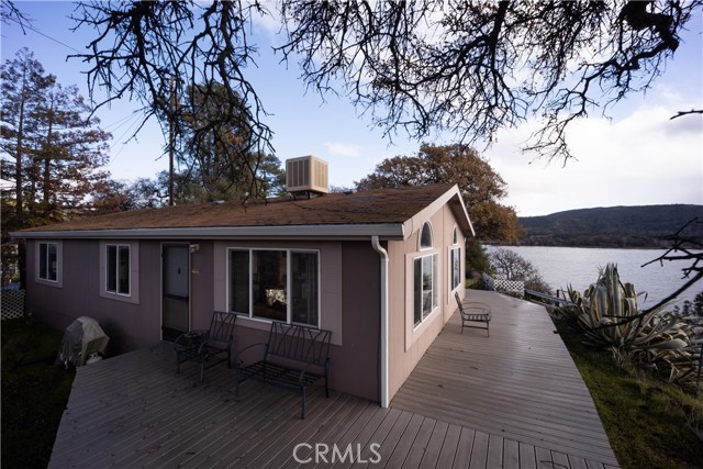 Perched on a rock bluff on Clearlake Oaks Island with Unparalleled Views of Clearlake, Rattlesnake Island & Mt. Konocti ~ this 2 bed / 2 bath manufactured home has 1,144 SF built in 1999, situated on nearly 1/2 acre LAKE FRONT parcel! Enter to find an open concept floorplan that offers vaulted ceilings + fan, built-in book shelving and several picture windows that allow the bright light and outstanding views to flow in. The kitchen with breakfast bar and adjoining dining area offers plenty of entertaining options. Indoor laundry room is a bonus! The primary bedroom has vaulted ceilings + fan while the primary bathroom offers a walk-in shower + linen closet. Newer wrap-around composite decking for your outdoor enjoyment! Stargaze, bird watch and soak up the incredible views surrounding! Lake access can be easily obtained by adding stairs down to the water. Detached converted garage/work-shop & an additional shed for your storage needs. Clearlake Oaks offers a launch & beach area just a few blocks away with restaurants & shopping within minutes of the home. Enjoy lake living with an affordable price tag at this once of a kind home!
