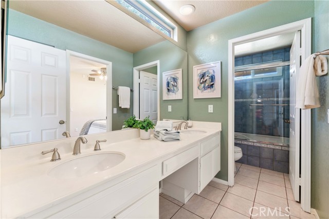 Upper full bathroom set between two bedrooms. Private commode and tub in shower. Double sinks and vanity area.