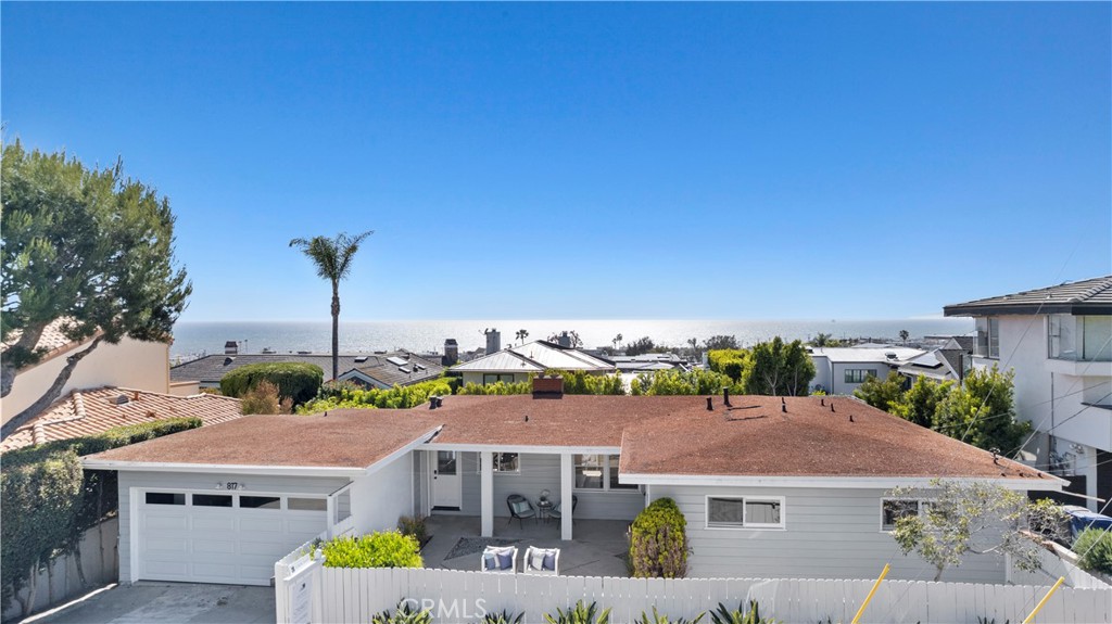 This charming mid-century home situated in the Hill Section of Manhattan Beach is a one-of-a-kind gem. The 1,500 square-foot,  three-bedroom, two-bathroom home sits on a huge 6,254 square-foot lot, offering a large yard and wide-reaching ocean views. Although move-in ready, the top of the hill location is a prime buildable lot that will feature 180-degree views from the potential second and third floors.  Reminiscent of a Hollywood Hills 1950s bungalow on the outside, but newly renovated inside, this residence makes a statement. The private front yard is inviting and cozy, a perfect place to host cocktail hour or enjoy a book. The ultra-modern kitchen features a Mid-Century modern fireplace. Sleek tiles, polished countertops, and stainless steel appliances offer function and beauty, while the dining nook’s corner of windows brings light and views. The living room is clean, bright, and airy and gets the second half of the super-cool central white brick fireplace. The Primary Bedroom boasts tons of windows and a view of the private backyard. The bathrooms are fully renovated, bringing a clean spa-like feeling to the home. This cozy bungalow is perfectly placed in the Hill Section. It’s quiet yet serene while being just steps from the action of downtown Manhattan Beach. It’s a short walk to Robinson Elementary and less than two miles from Mira Costa, it’s the perfect family home.
