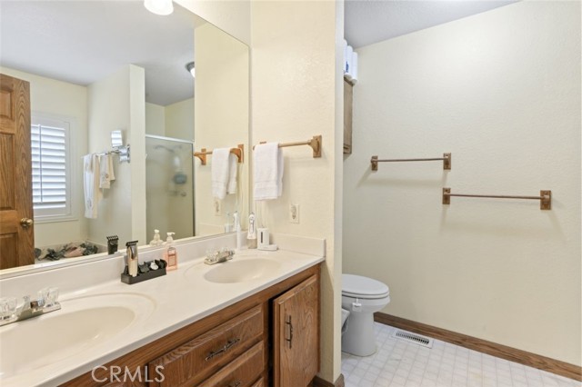 Primary bathroom w dual sinks and separate tub and shower in the mirro