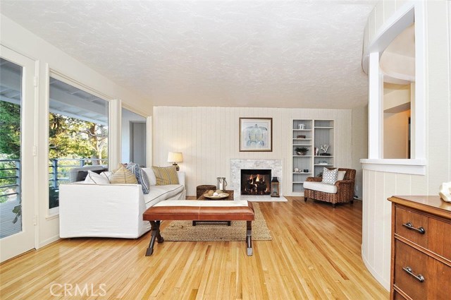Beautiful living room with hardwood floors and marble fireplace.