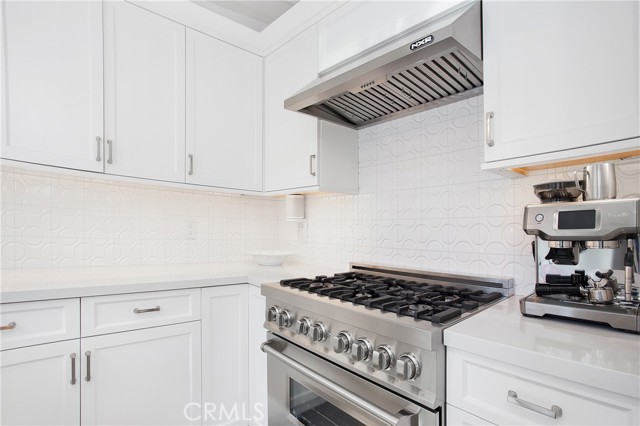 6 burner commercial grade range, tile backsplash and quartz counters.