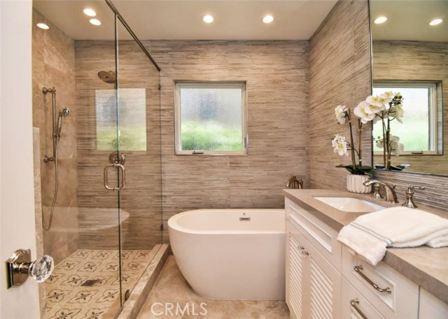 Tastefully remodeled master bathroom with a free-standing bathtub and spacious shower stall
