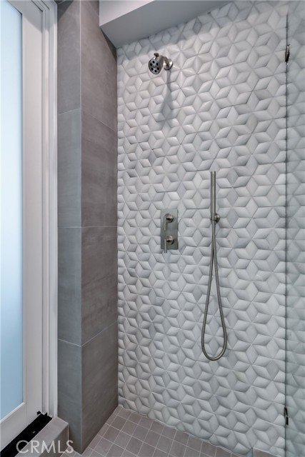 Beach room shower with marble tile walls