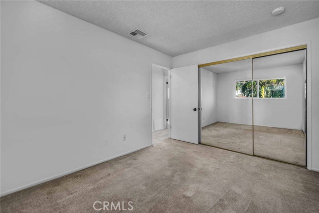 Smaller bedroom with a mirror closet.   The  bathroom is across the hall