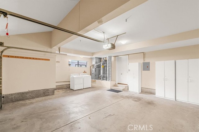 Spacious garage with laundry and additional storage cabinets