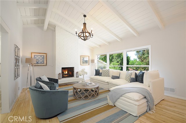 Living room with vaulted ceiling and a cozy fireplace