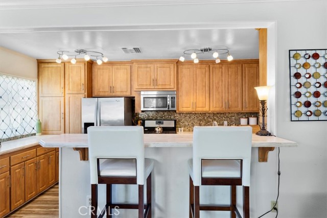 Kitchen has breakfast bar with seating and is open to family room.