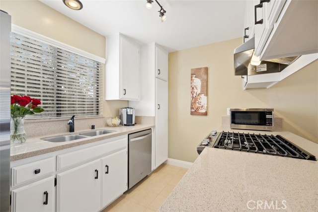 Well appointed kitchen with stainless steel appliances and quartz countertops