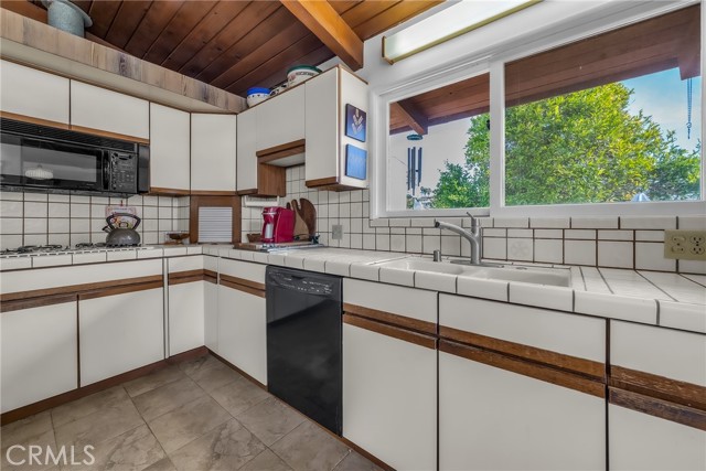 Kitchen with  microwave, dishwasher, and a view of the side yard and East.