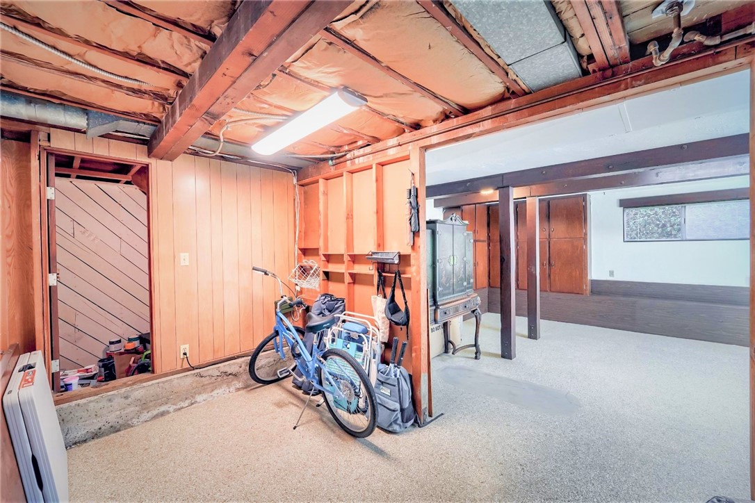 The storage area off of the bonus room is perfect for bikes or other items. To the left there is a door leading to the garage. Past the storage is another area which could be a wine cellar or an area for keeping additional items.