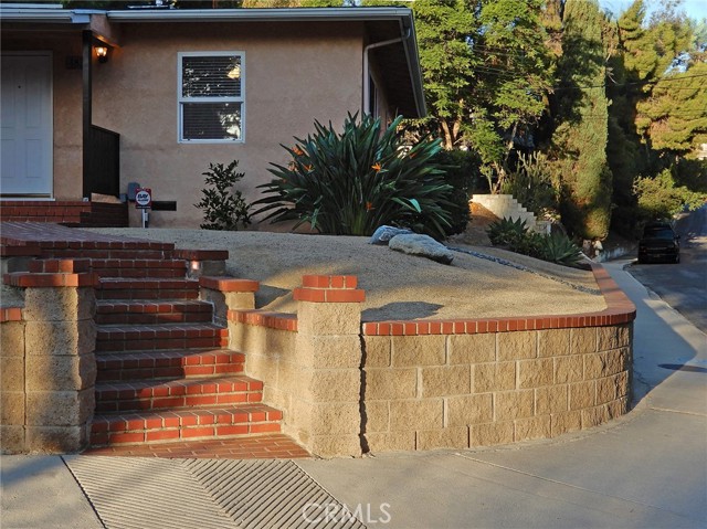 Retaining wall made with tan split-face cinderblock and red-brick caps