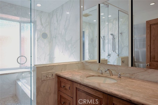 Tan Breccia Onicata marble countertop; Robern mirrored cabinets; Polk speakers for karaoke