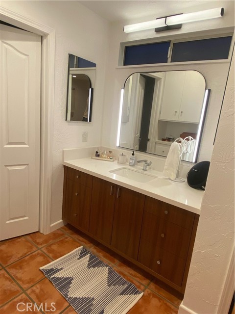 Primary bathroom has remodeled vanity and lighting.