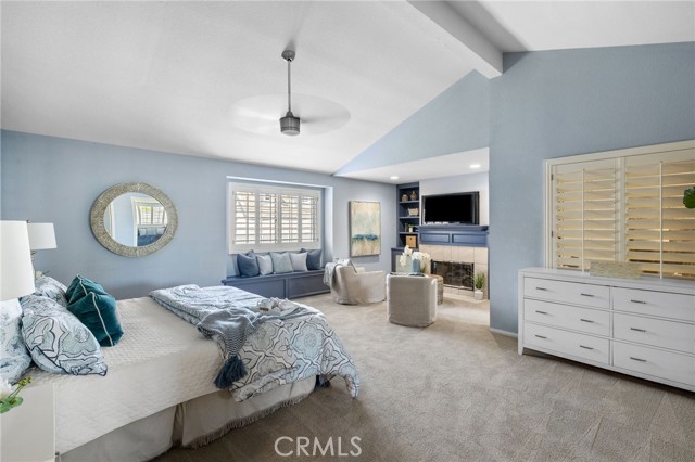 Owner's Suite with sitting area in front of fireplace and built-in bookcases