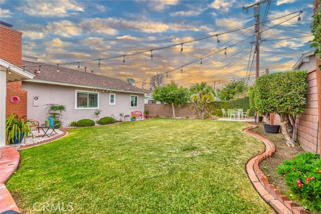 Backyard grass is well-manicured with perfect green in the spring. In the distance, lemon and avocado trees