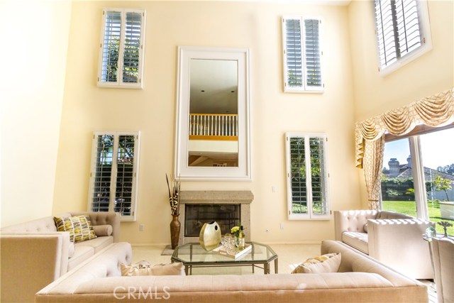 Soaring high ceilings and lots of light in this living room with a fireplace