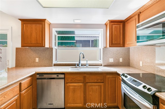 Kitchen has granite counters and backsplash, and a garden window.