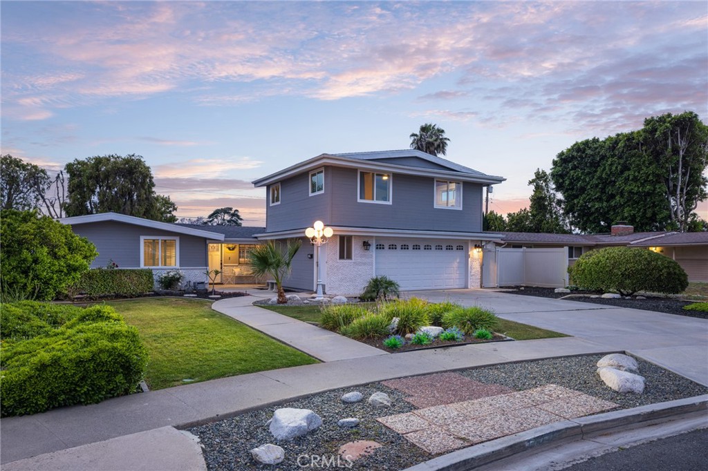 Your ultimate turnkey opportunity awaits at this masterfully expanded and upgraded Mid-Century ranch home in North Tustin, which offers an immensely sought-after location, a spacious floor plan and outstanding income potential. Generously sized at approximately 2,242 square feet, the residence presents the convenience and style of single-level living, with the second floor reserved for a custom ADU over the two-car garage. This income-generating space boasts a separate address and a kitchenette. Four bedrooms and two- and one-half baths join an open living area with vaulted ceilings that soar over a fireplace-warmed living room and a custom-caliber chef’s kitchen. Serve up casual meals and tempting appetizers at the kitchen’s island, while stainless steel appliances, a stainless apron sink, white Shaker cabinetry, quartz countertops, a full-height tile backsplash, and a walk-in pantry with designer tile and wine refrigerator make meal prep and entertaining easy and fun. A fresh, modern aesthetic is enjoyed throughout and complemented by custom designer tile and quartz countertops in bathrooms, sleek lighting fixtures, oversized floor tile in select rooms and wood-look plank flooring. Custom closets, a brand-new roof, new exterior paint and siding, and new energy-efficient windows and sliding-glass doors are also featured. Grounds embrace approximately 10,578 square feet and display a welcoming front yard, mature landscaping, and a tranquil zen-inspired backyard with a large paver-finished patio. This prized North Tustin neighborhood is convenient to award-winning Blue Ribbon schools, including Guin Foss Elementary School, Hewes Middle School and Foothill High School. Numerous parks are close by, and Old Town Tustin’s charming boutiques, cafés and restaurants are only minutes from home.