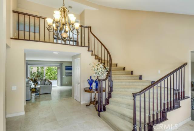 Elegant entrance with rounded staircase and Travertine flooring