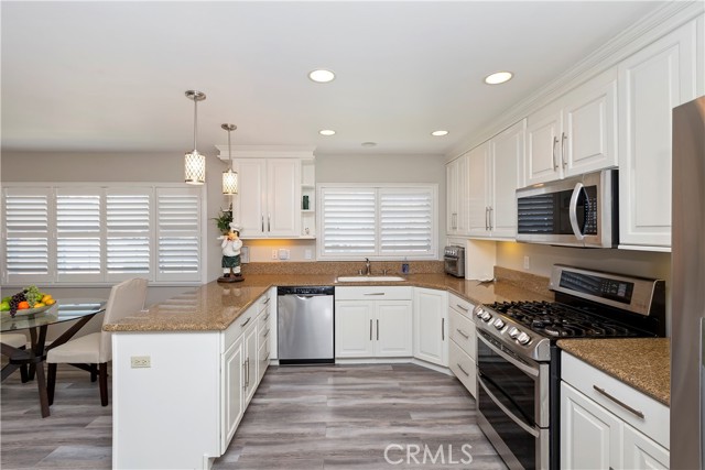 Kitchen - Brilliant white cabinetry pairs beautifully with the granite countertops and the stainless steel appliances.