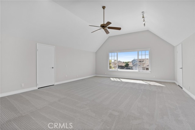 The HUGE bonus/game room or another primary suite has vaulted ceilings and access to an attic storage area!